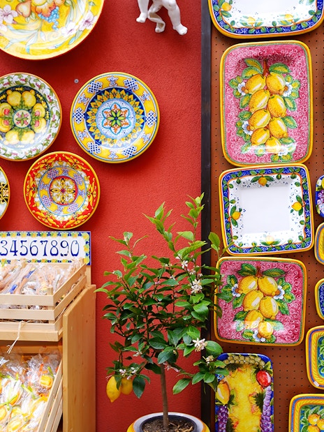 Colorful ceramic plates and lemon-themed pottery on display in Sorrento shop.