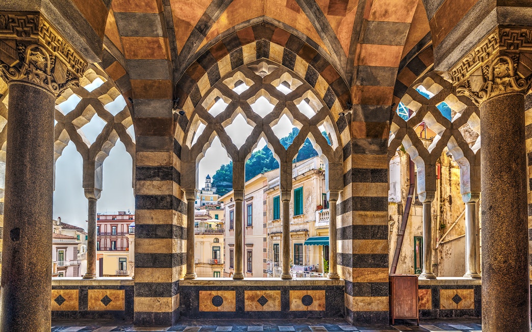 Arched colonnade view of Amalfi buildings on a guided tour from Naples.