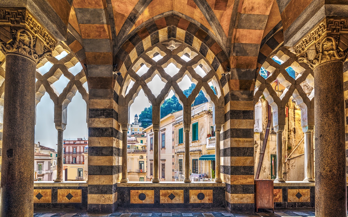 Arched colonnade view of Amalfi buildings on a guided tour from Naples.