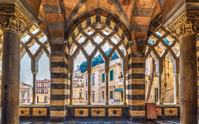 Arched colonnade view of Amalfi buildings on a guided tour from Naples.