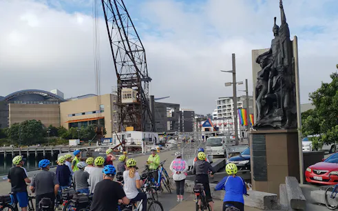 Cyclists gather near a waterfront sculpture during a Wellington guided bike tour.