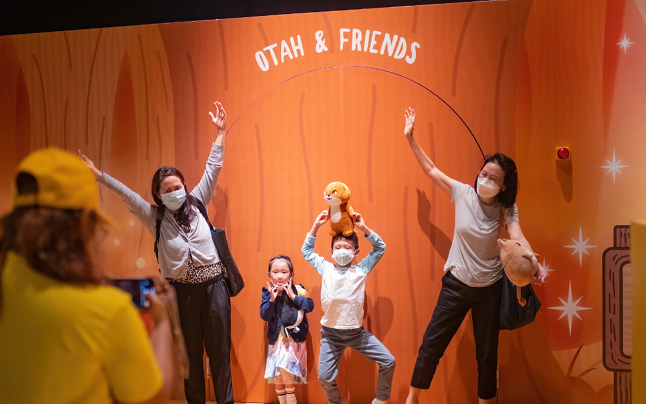 Visitors posing with plush toys at Otah & Friends: Camp Stardust exhibit.
