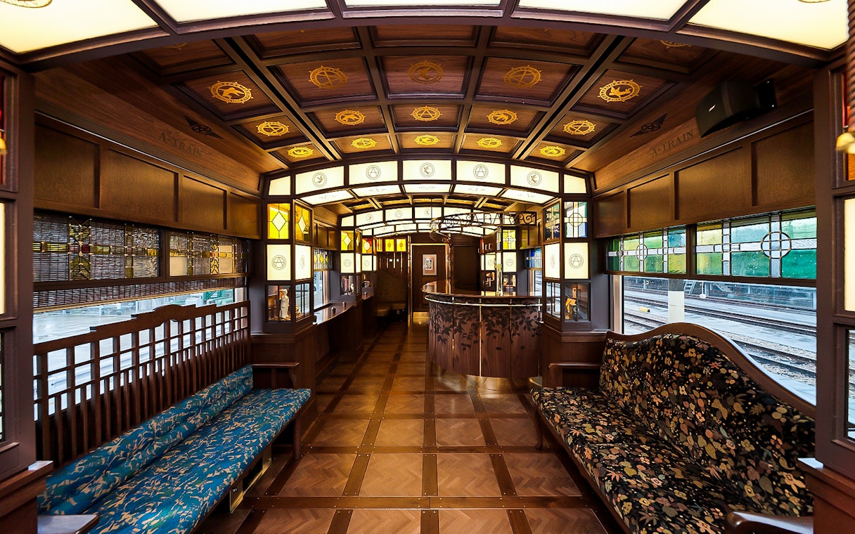 Luxurious interior of a vintage train in Southern Kyushu, featuring ornate woodwork and stained glass.