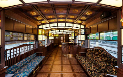 Luxurious interior of a vintage train in Southern Kyushu, featuring ornate woodwork and stained glass.