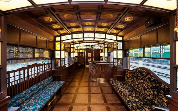 Luxurious interior of a vintage train in Southern Kyushu, featuring ornate woodwork and stained glass.