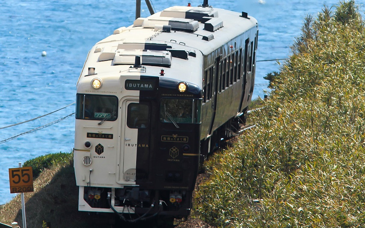 Train traveling along the coast in Southern Kyushu, Japan, with ocean view.