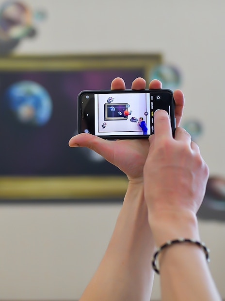 Person photographing illusion art at Illusion Art Museum Prague.