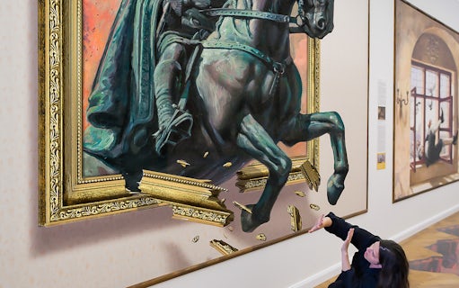 Horse sculpture illusion at Illusion Art Museum Prague with visitor interacting.