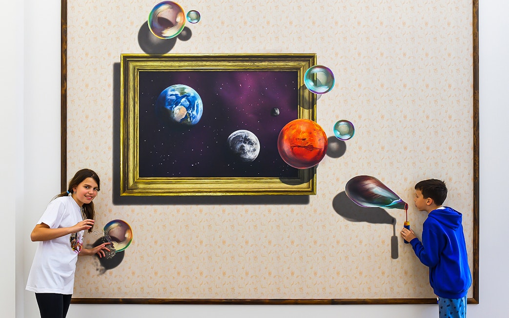 Visitors interacting with a 3D space-themed artwork at Illusion Art Museum Prague.