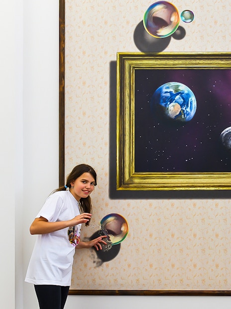 Visitors interacting with a 3D space-themed artwork at Illusion Art Museum Prague.