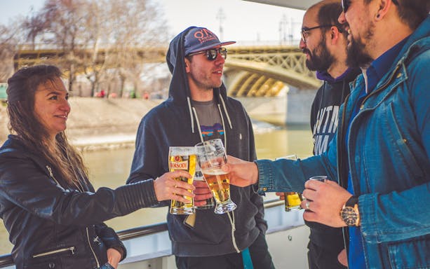 Guests toasting with beer on a New Year's Day cruise in Budapest.