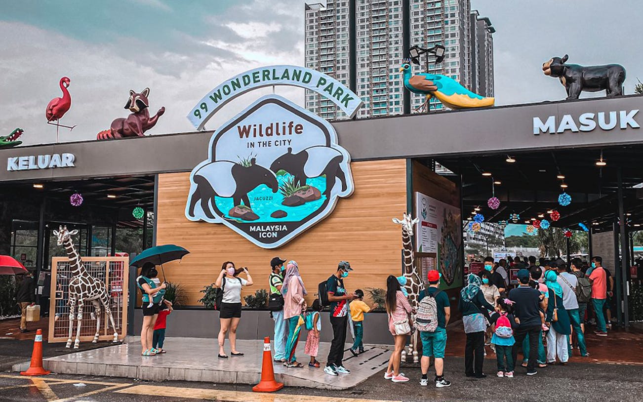Visitors entering 99 Wonderland Park in Malaysia, featuring wildlife-themed decor.