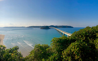 Bridge over turquoise sea in Yamaguchi, Japan, viewed from a lush green hill.