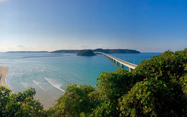 Bridge over turquoise sea in Yamaguchi, Japan, viewed from a lush green hill.