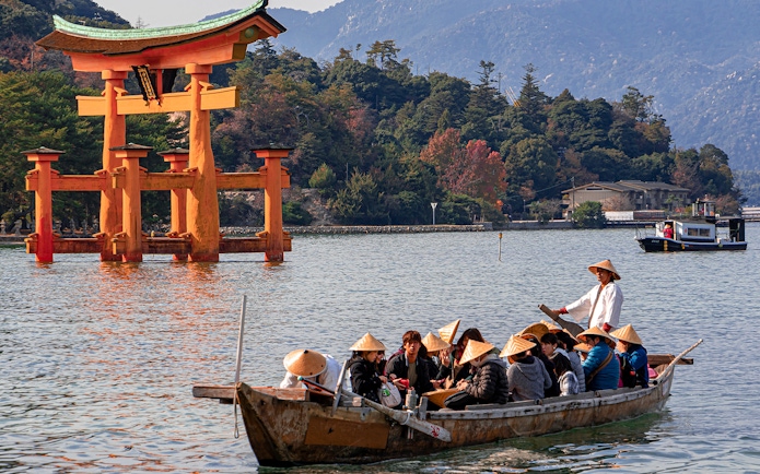 Boat tour near Itsukushima Shrine's torii gate, Hiroshima, Japan.
