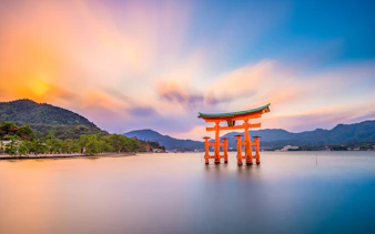 Torii gate at Itsukushima Shrine, Miyajima Island, Japan, during sunset.
