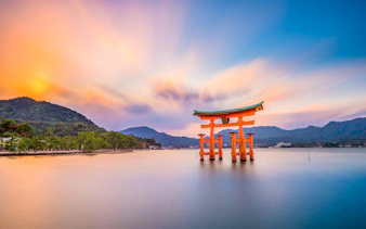 Torii gate at Itsukushima Shrine, Miyajima Island, Japan, during sunset.