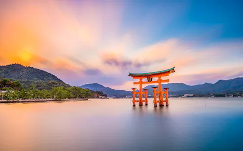 Torii gate at Itsukushima Shrine, Miyajima Island, Japan, during sunset.