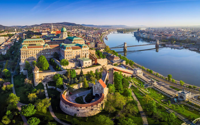 Aerial view of Buda Castle and Chain Bridge along the Danube River in Budapest.
