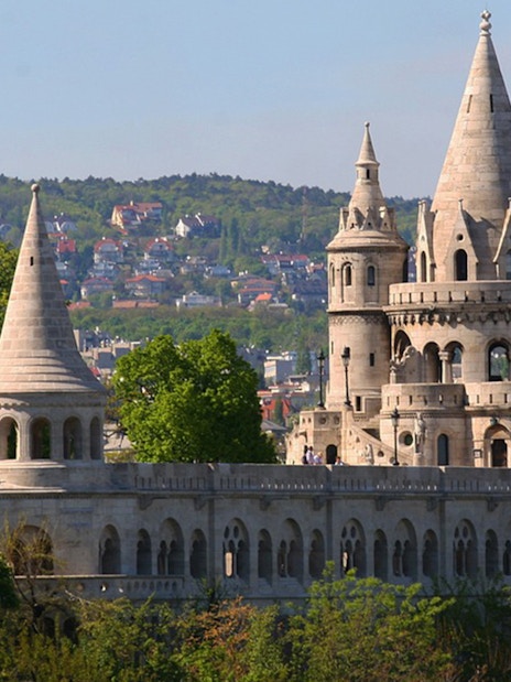 Fisherman's Bastion towers in Budapest with cityscape in the background.