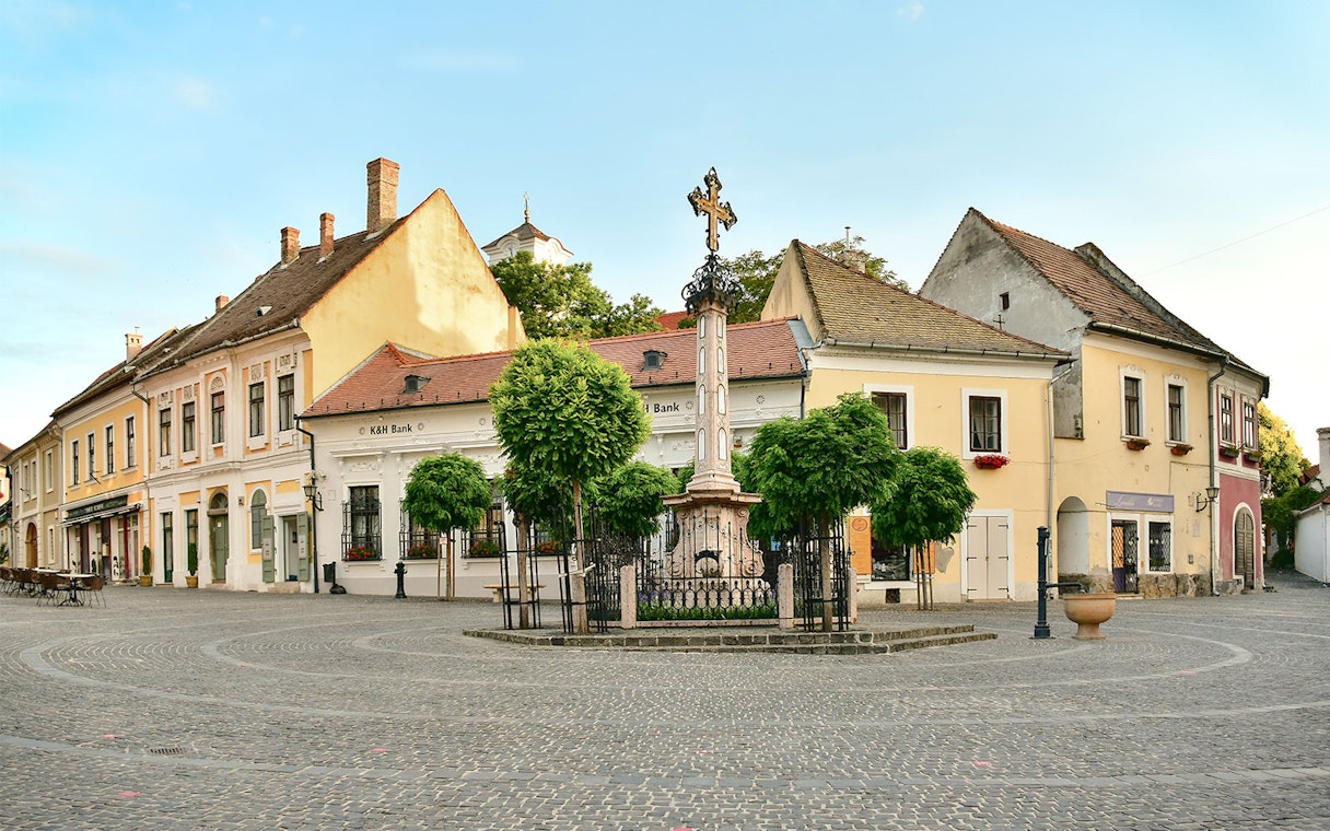 Szentendre town square with historic buildings and a central cross monument.