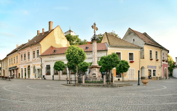 Szentendre town square with historic buildings and a central cross monument.