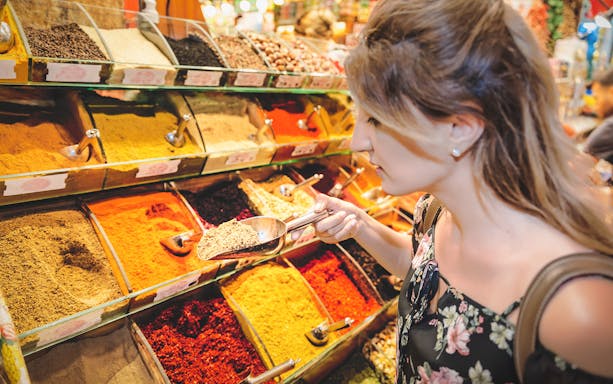Person exploring spice stall at Grand Bazaar during walking tour.
