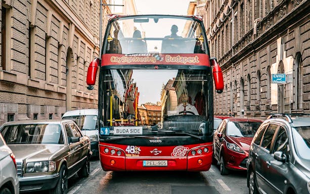 Red double-decker bus on Budapest street for hop-on hop-off tour.