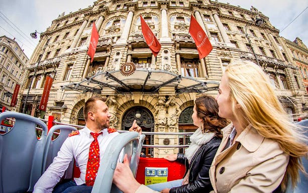 Open-top bus tour passing Boscolo Hotel in Budapest.