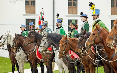 Hungarian hussars on horseback in traditional attire at Gödöllő Palace, Budapest.