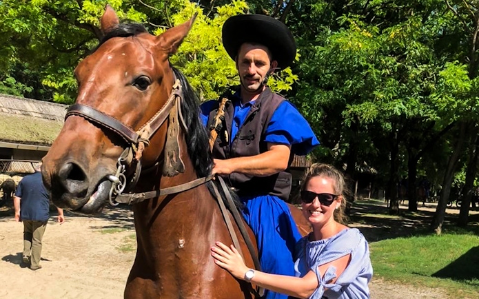 Horseman in traditional attire with tourist during Puszta day trip in Kecskemet, Hungary.