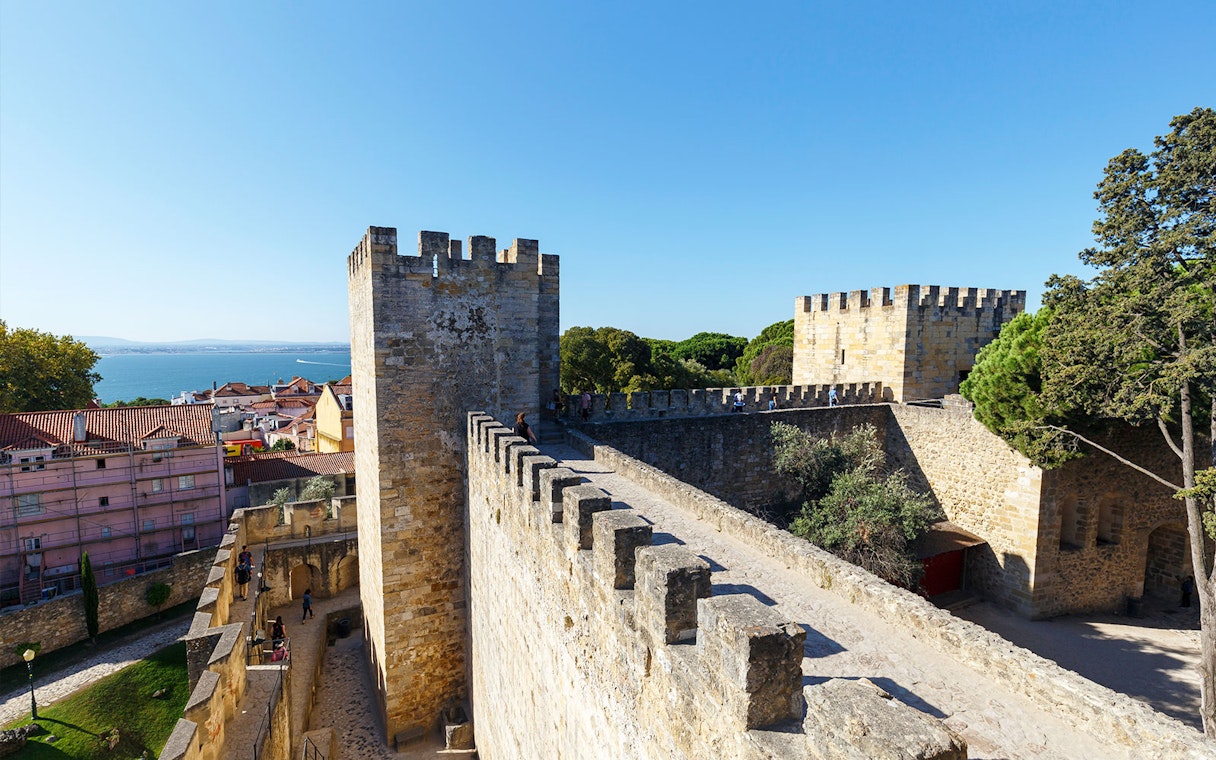 Surrounding wall of St. George’s Castle in Lisbon with city and sea view.