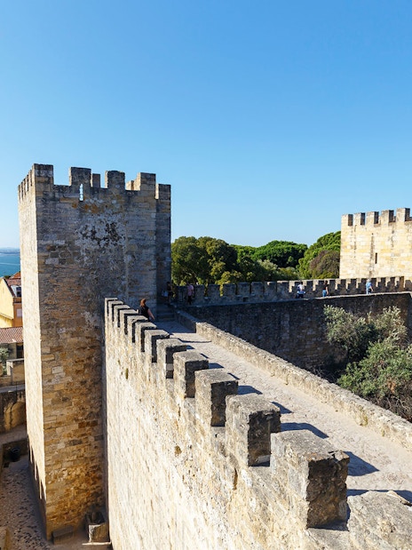 Surrounding wall of St. George’s Castle in Lisbon with city and sea view.