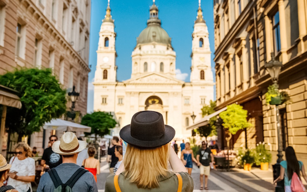 Tourists walking towards St. Stephen's Basilica in Budapest during a guided tour.