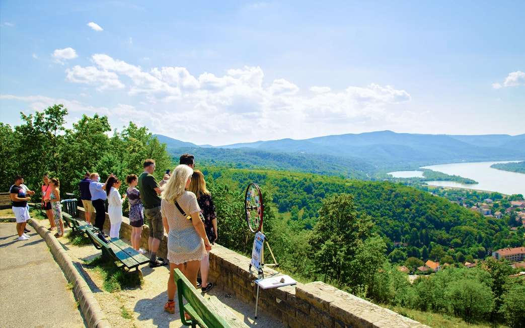 Tourists enjoying the scenic view of the Danube Bend from a lookout point near Budapest.