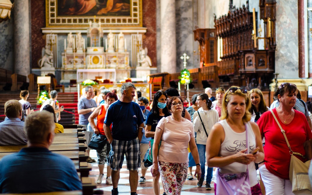 Tourists exploring the interior of a historic church on the Danube Bend bus tour from Budapest.