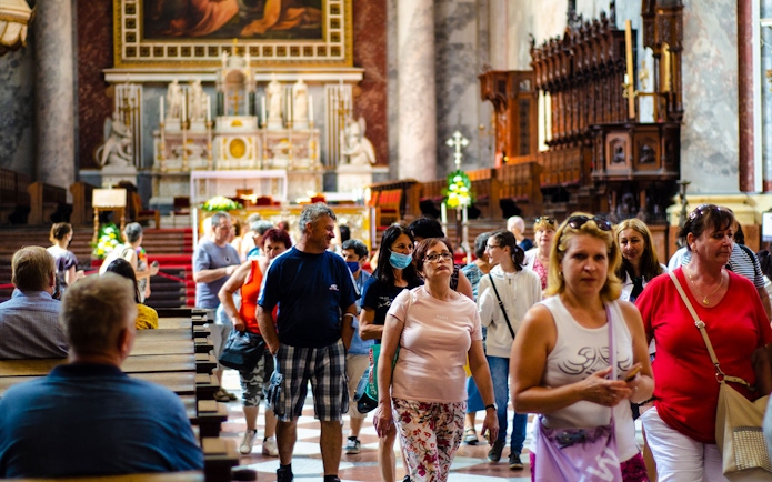 Tourists exploring the interior of a historic church on the Danube Bend bus tour from Budapest.