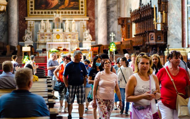 Tourists exploring the interior of a historic church on the Danube Bend bus tour from Budapest.
