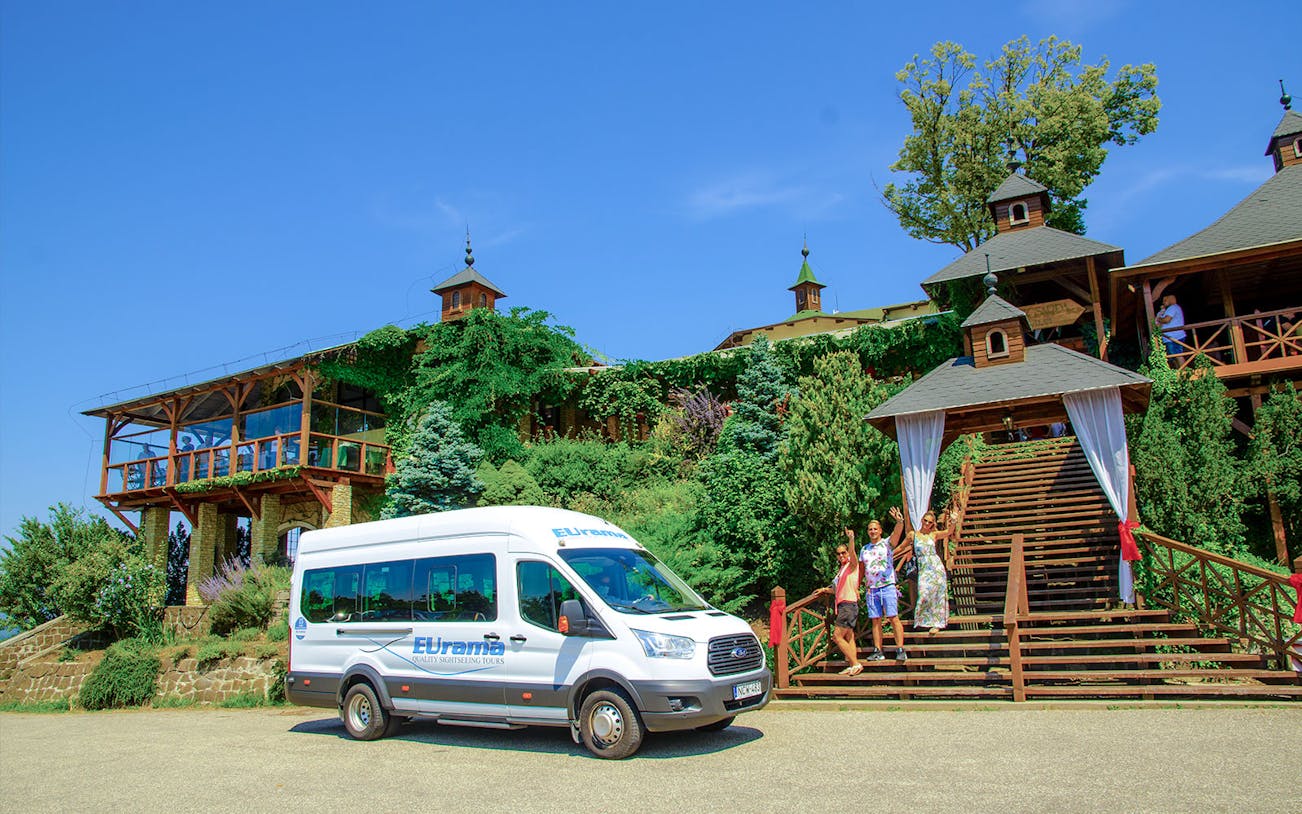Danube Bend tour bus parked near a scenic building with tourists in Budapest.