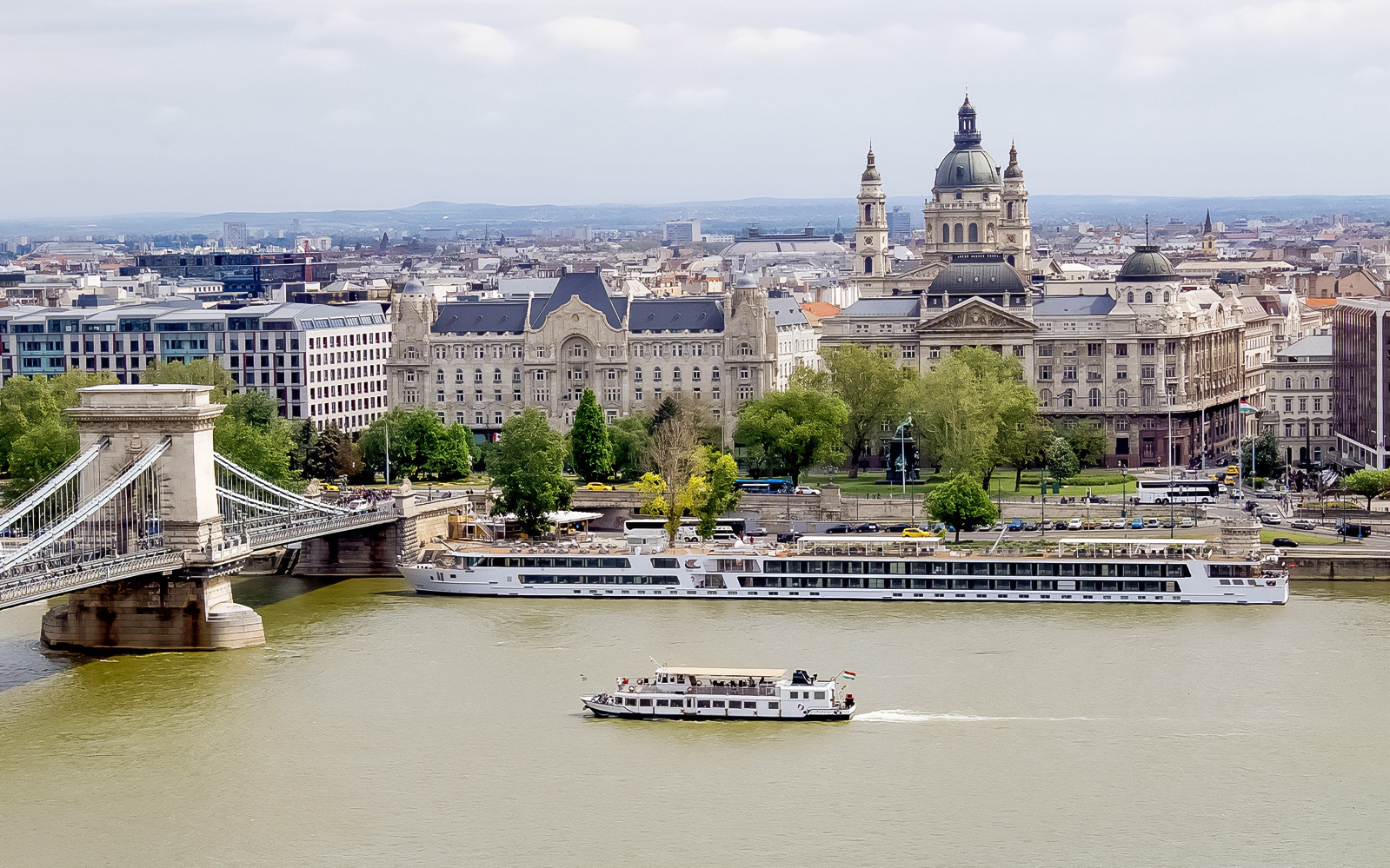 Danube River cruise boat with tourists, Budapest Parliament building in view, 1-hour sightseeing tour.