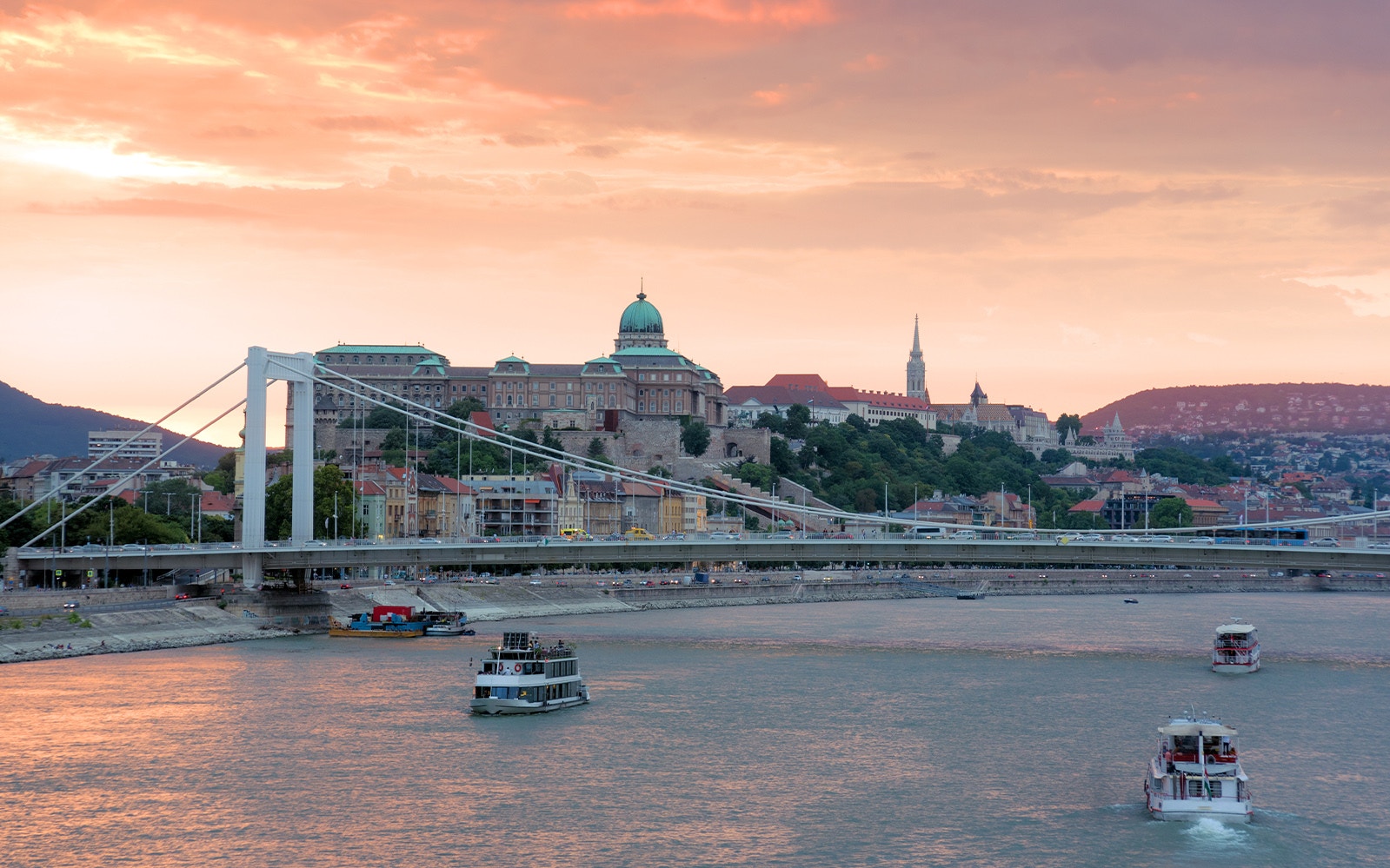 Danube River cruise boat with tourists, Budapest Parliament building in view, 1-hour sightseeing tour.