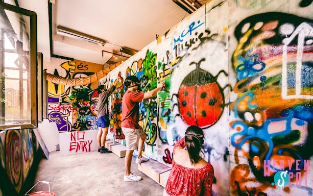 Visitors spray painting graffiti at Heaven Spot Graffiti Warehouse, Singapore.