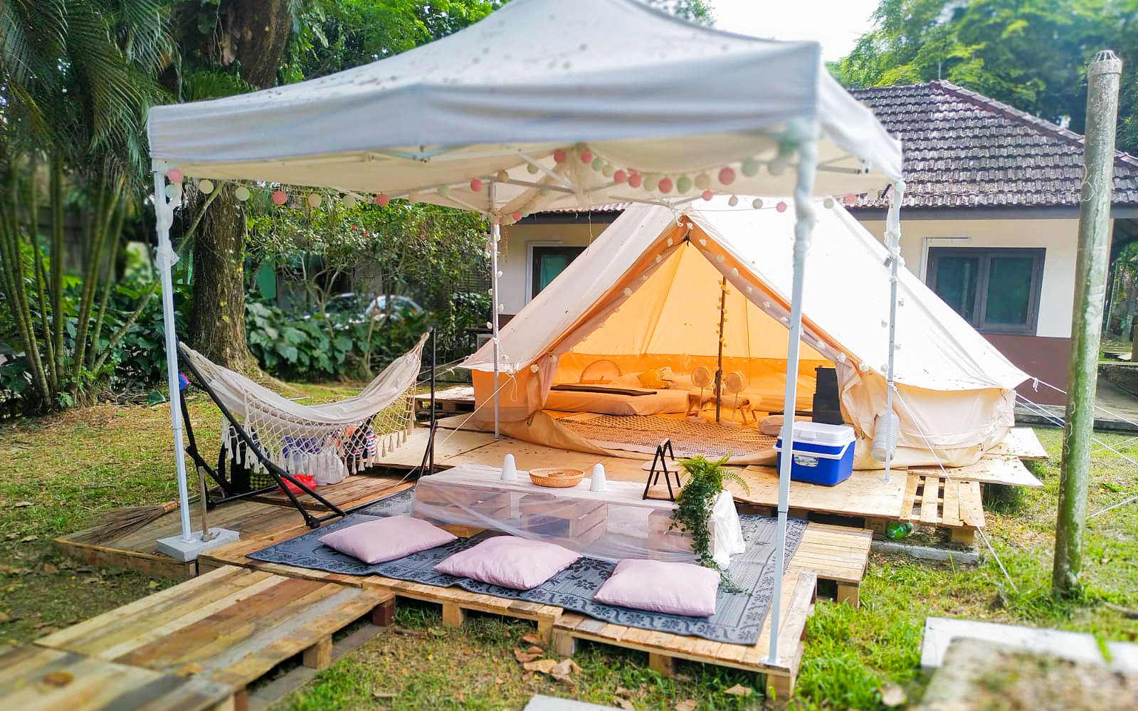 Glamping tent setup with hammock and outdoor seating at a Glamping Society location.