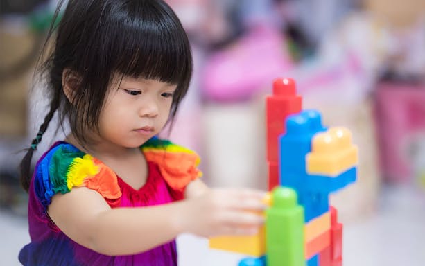 Child playing with colorful blocks at T-Play Bukit Batok indoor playground.