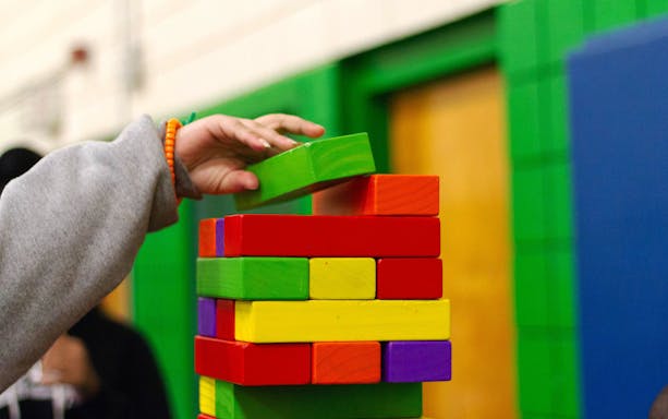 Child stacking colorful blocks at T-Play Bukit Batok indoor playground.