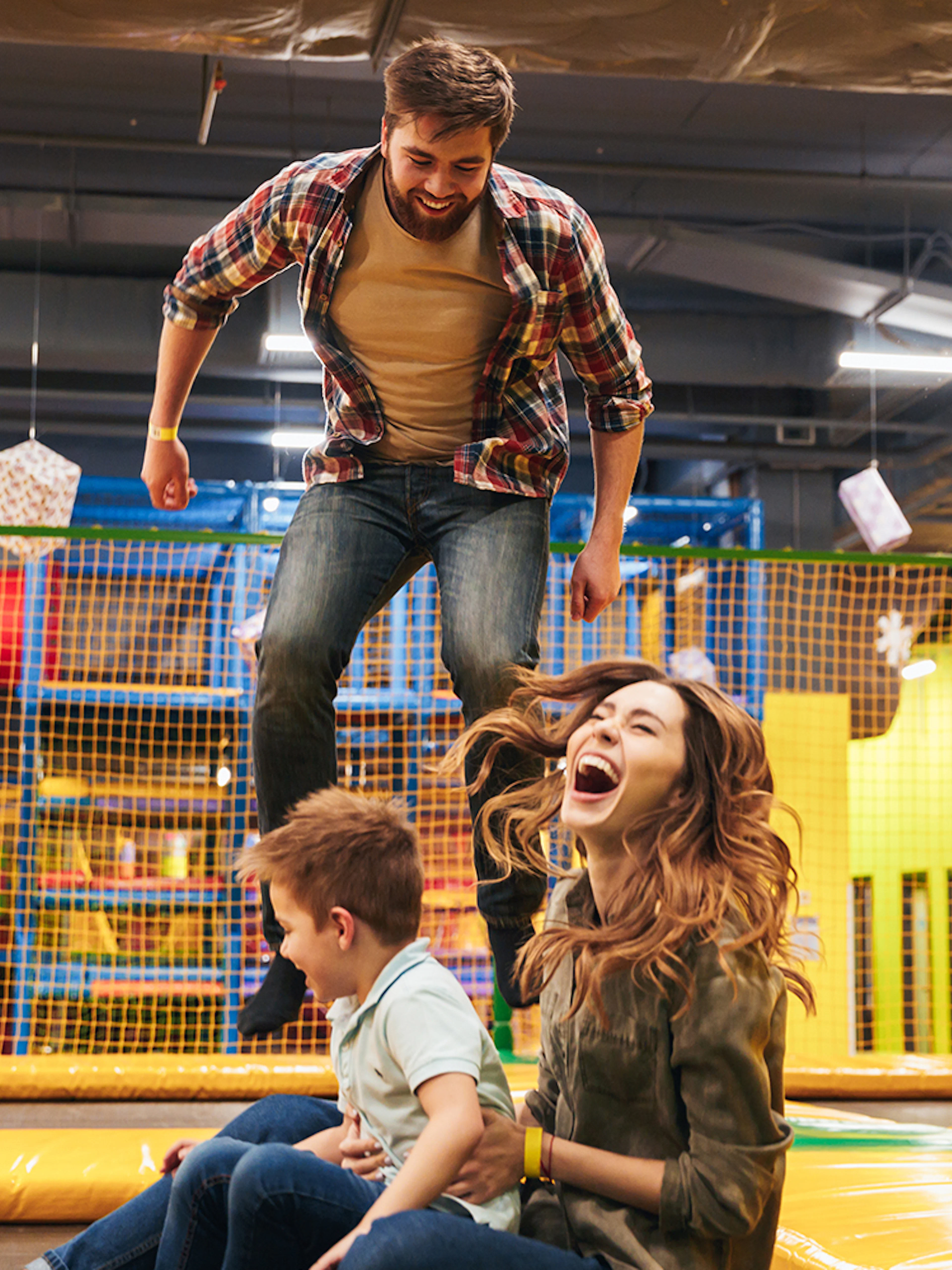 Family enjoying trampoline play area at T-Play Khatib indoor playground.