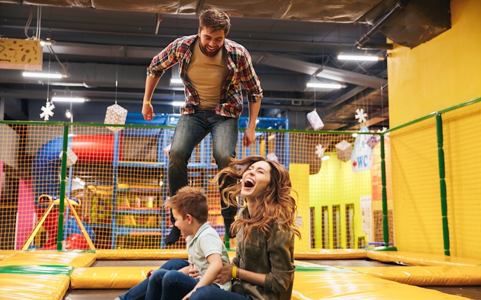 Family enjoying trampoline play area at T-Play Khatib indoor playground.