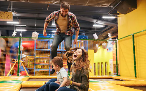 Family enjoying trampoline play area at T-Play Khatib indoor playground.