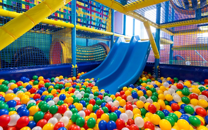 Indoor playground with blue slides and colorful ball pit at T-Play Khatib.