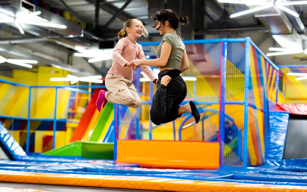 Children jumping on trampolines at T-Play Khatib indoor playground.